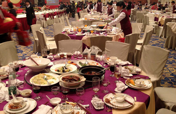 Waitresses clear tables, after a dinner for staff members from a state-owned enterprise at a five-star hotel in Guangzhou, Guangdong province, China.   Xinhua News Agency
