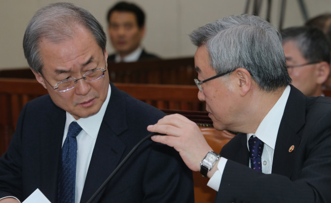Minister of Foreign Affairs and Trade Kim Sung-hwan (right) confers with Minister of Trade Bark Tae-ho at the National Assembly’s Foreign Affairs, Trade and Unification Committee meeting on Monday.   Yonhap News