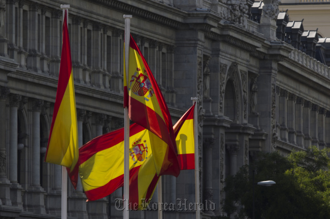 Spanish national flags fly outside the Bank of Spain headquarters in Madrid.   Bloomberg
