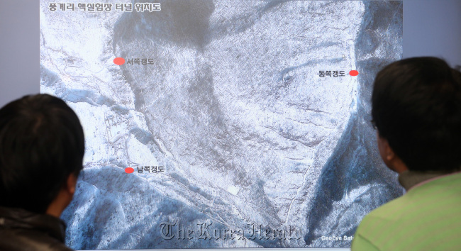 A man looks at a satellite image of North Korea’s nuclear test site in Punggye-ri.Yonhap News