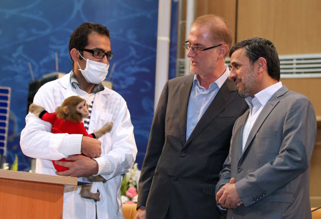 Iranian President Mahmoud Ahmadinejad (right) looks at a space monkey during a ceremony to mark Iran’s National Day of Space Technology in Tehran on Monday.   AFP-Yonhap News
