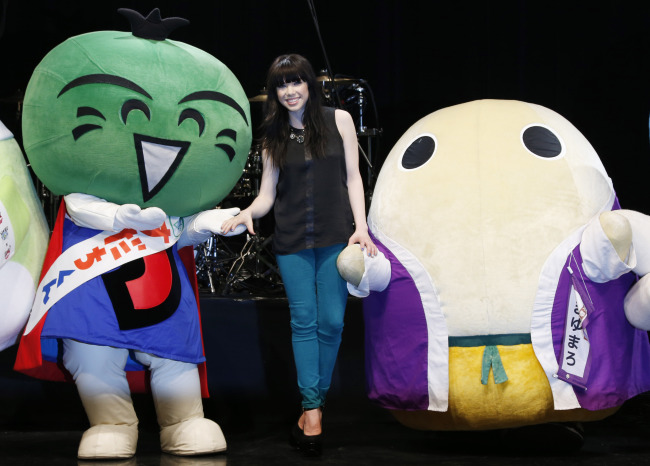 Canadian singer Carly Rae Jepsen smiles during a photo session with Japan’s local mascot characters before her concert in Tokyo, Friday.   AP-Yonhap News