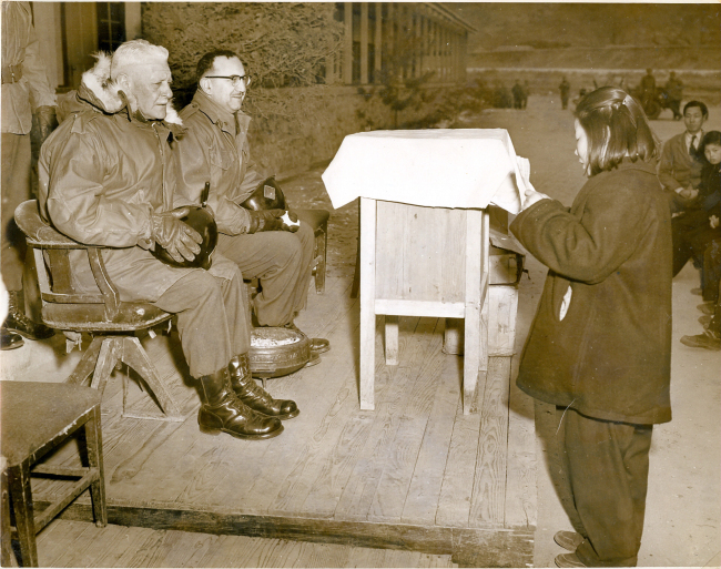 This undated photo released by the Ministry of Patriots and Veterans Affairs shows Gen. Joseph Cleland (left), commander of then U.S. Army 40th Infantry Division, attending a graduation ceremony at Kaiser Middle and High School, now Gapyong High School, during the Korean War.   Yonhap News