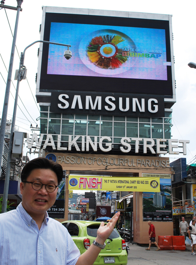 Professor Seo Kyeong-duk poses in front of the bibimbap ad at Walking Street in Thailand. (Yonhap News)