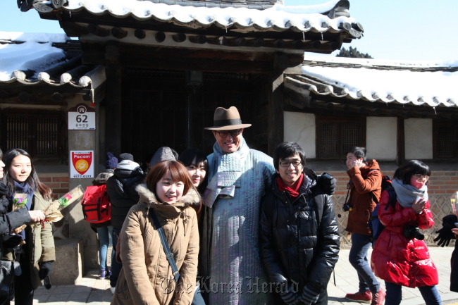 Korea Tourism Organization CEO Lee Charm (center) poses with Chinese tourists during a guided tour to Bukchon Hanok Village in Seoul on Thursday.    The Korea Tourism Organization