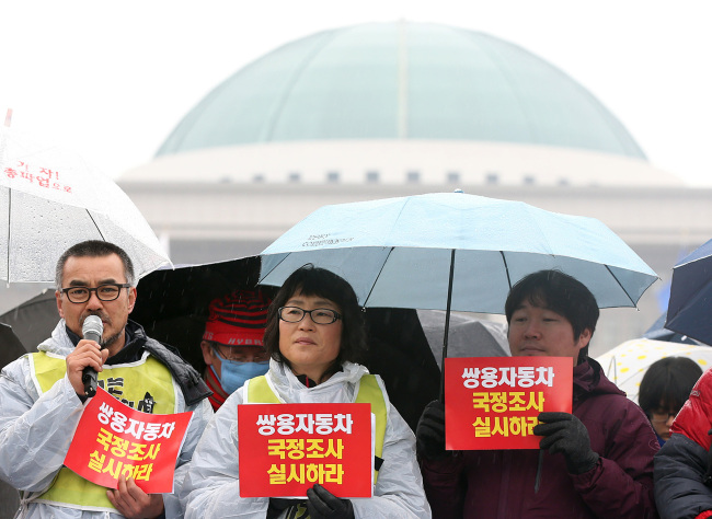 A group of labor activists holds a news conference in front of the presidential transition committee building in central Seoul to call for reinstatement of the dismissed Ssangyong Motor last week.   Yonhap News