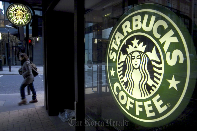 A pedestrian passes a Starbucks in central London.   Bloomberg