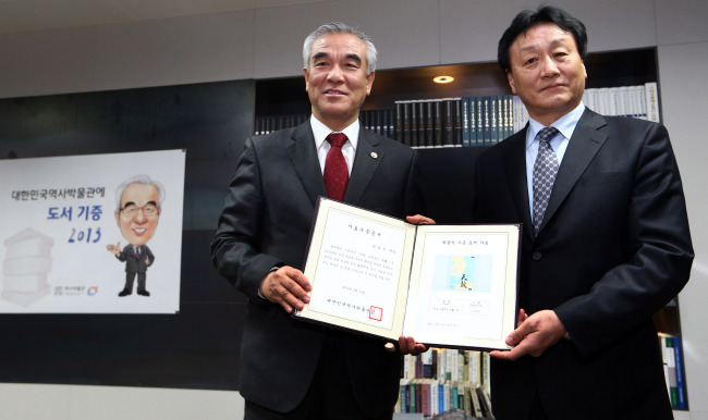 최광식(좌측/문화체육관광부장관),김왕식(학원인)
Culture Minister Choe Kwang-shik (left) receives a certificate of donation from Kim Wang-shik, director of the National Museum of Korean Contemporary History, on Wednesday after donating 2,013 books to the museum.   Yonhap News