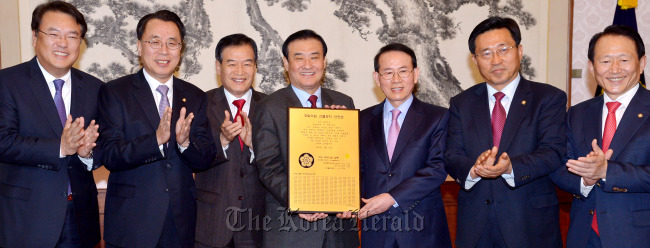 National Assembly Secretary-General Chung Jin-suk (from left); Saenuri Party lawmakers Kim Hoe-sun, Suh Sang-kee and Speaker Kang Chang-hee; Min Byoung-chul, founder of the Sunfull Movement; and lawmakers Kim Choon-jin of the Democratic United Party and Kim Jong-tae of the Saenuri Party pose in a ceremony to present a plaque of the names of Sunfull activist lawmakers to Kang at the speaker’s office on Wednesday.   Park Hyun-koo/The Korea Herald