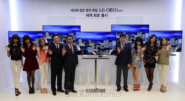 Kwon Hee-won (fourth from right), president of the home entertainment business at LG Electronics, and other executives introduce the new 2013 TV lineup with members of Girls’ Generation at a ceremony in southern Seoul on Thursday.   Park Hae-mook/The Korea Herald