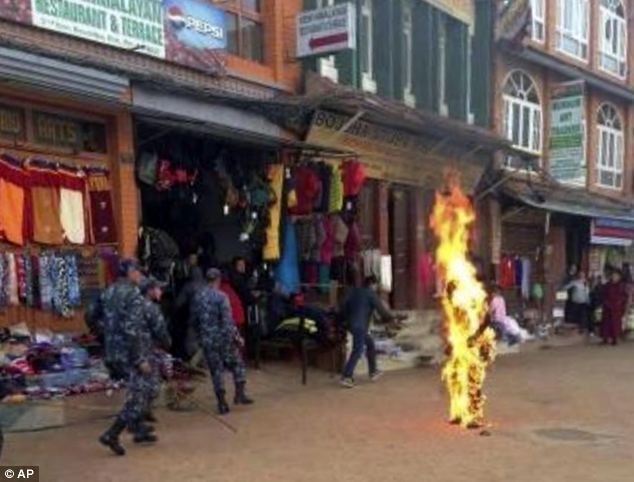 Police rush to a Tibetan monk who set himself on fire at the premises of the Boudhanath Stupa in Kathmandu on Wednesday. (AP)