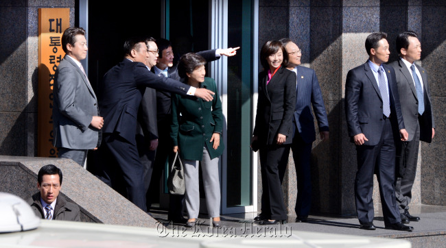 President-elect Park Geun-hye (center) surrounded by officials reacts to calls from bystanders as she enters the transition committee office building in Samcheong-dong, Seoul, for a debate on Friday. Her government preparation remains incomplete while her prime minister and ministers-designate await confirmation hearings by the National Assembly.   Park Hae-mook/The Korea Herald