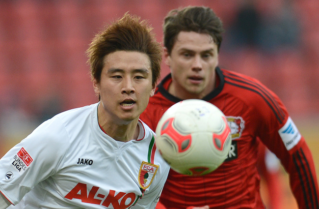 Augsburg’s Koo Ja-cheol (left) and Leverkusen’s Sebastian Boenisch challenge for the ball on Saturday. Augsburg lost 2-1.   AFP-Yonhap News