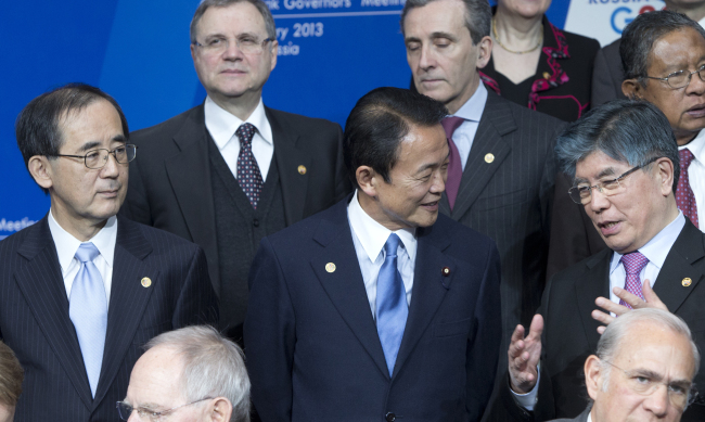 Bank of Korea Governor Kim Choong-soo (right), Bank of Japan Governor Masaaki Shirakawa (left) and Japanese Finance Minister Taro Aso attend a group photo ceremony at a meeting of G20 finance ministers and central bank governors in Moscow on Saturday.   AP-Yonhap News