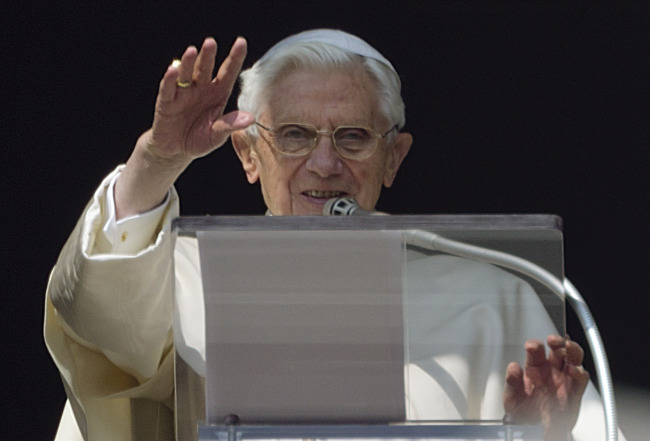 Pope Benedict XVI acknowledges a cheering crowd of faithfuls and pilgrims during his Angelus prayer from the window of his apartment at the Vatican on Sunday.   AP-Yonhap News