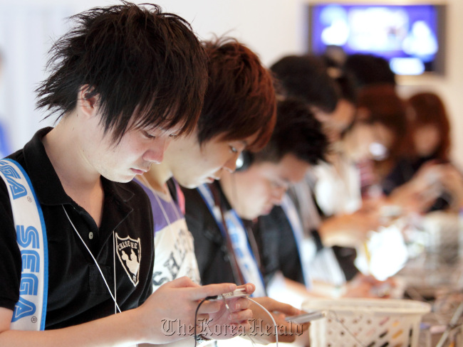 Visitors play game at the Tokyo Game Show 2012 at Makuhari Messe in Chiba, Japan.   Bloomberg
