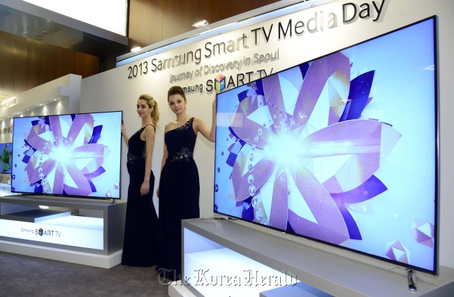 Models pose with new Samsung smart TV sets at a launch in Seoul on Tuesday.   Park Hae-mook/The Korea Herald