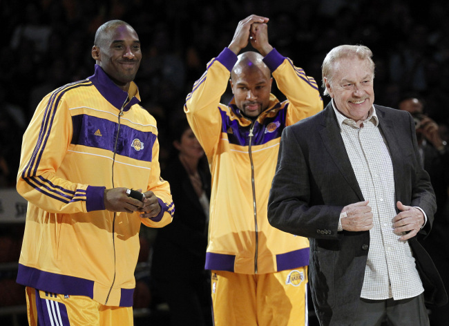 Los Angeles Lakers owner Jerry Buss (right) walks out onto the court during the NBA championship ring ceremony as Kobe Bryant (left) and Derek Fisher look on before a basketball game against the Houston Rockets in Los Angeles, Oct. 26, 2010.    AP-Yonhap News
