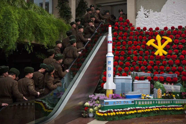 <YONHAP PHOTO-1285> North Korean soldiers ride an escalator past a model of their country's Unha Rocket as they enter an exhibition in Pyongyang on Sunday, Feb. 17, 2013 where Kimjongilia flowers, named after the late North Korean leader Kim Jong Il, were on display. (AP Photo/David Guttenfelder)/2013-02-17 19:16:57/ <저작권자 ⓒ 1980-2013 ㈜연합뉴스. 무단 전재 재배포 금지.>
North Korean soldiers ride an escalator past a model of their country’s Unha Rocket as they enter an exhibition on Sunday in Pyongyang, where Kimjongilia flowers, named after the late North Korean leader Kim Jong-il, were on display. AP-Yonhap News