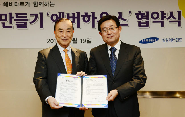 Samsung Everland CEO Kim Bong-yung (right) poses with Habitat for Humanity Korea chief Chung Kun-mo after donating funds to the charity
organization in Seoul on Tuesday.   Yonhap News