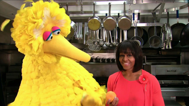 This undated handout video frame grab provided by the White House shows first lady Michelle Obama with Sesame Street’s Big Bird in the kitchen of the White House in Washington.   AP-Yonhap News