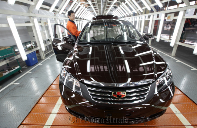 A Geely Automobile Holdings Ltd. Emgrand EC7 sedan undergoes final inspection on the production line at the company’s factory in Cixi, Zhejiang Province, China.   Bloomberg