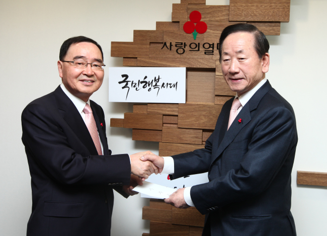정홍원(좌측/정무직공무원),이동건(기업인/사랑의열매대표)
Prime Minister Chong Hong-won (left) delivers his donation to Lee Dong-kurn, chairman of the Community Chest of Korea, at the charitable organization in Seoul on Wednesday.   Community Chest of Korea