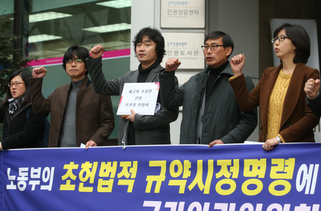 Members of the Korean Teachers and Education Workers Union hold a rally against the government before filing a petition to the National Human Rights Commission in Seoul on Tuesday. The union claimed that the government’s order to revise its bylaws that illegally recognize fired teachers as members infringes basic human rights.   Yonhap News