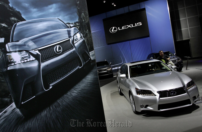 A worker cleans a Toyota Motor Corp. Lexus vehicle displayed at the company’s booth during the LA Auto Show in Los Angeles, California.    Bloomberg