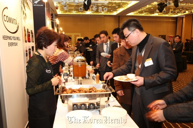 An event-goer gets a taste of a New Zealand food during the New Zealand Food Connection 2013 at Paradise Hotel in Busan on Tuesday.   New Zealand Embassy