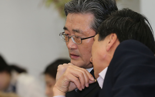 Saenuri Party floor leader Lee Han-koo (left) and deputy floor leader Kim Gi-hyeon confer before the meeting with Democratic United Party leaders at the National Assembly in Seoul on Sunday. (Yonhap News)