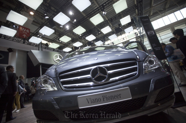 People examine Daimler AG Mercedes-Benz vehicles at the company’s stand during the auto show in Beijing.   Bloomberg