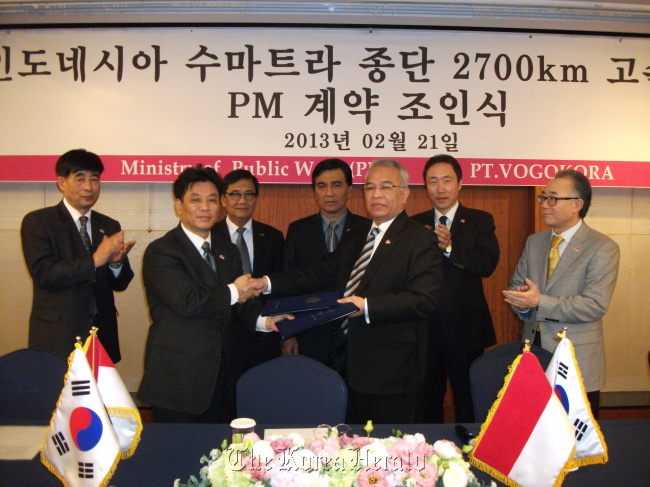Vogo Kora CEO and president Kwon Jeong-sang (second from left) shakes hands with Ahmad Ghani Gazaly, senior adviser to the Indonesian minister of public works, in a project management contract for a highway construction in Sumatra, Indonesia, at a ceremony in Seoul last month.     Vogo Kora