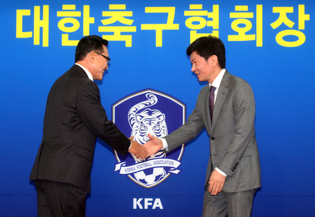 Chung Mong-gyu (right), the new president of the Korea Football Association, shakes hands with former president Cho Chung-yun during a ceremony in Seoul on Thursday.   Yonhap News