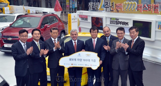 GM Korea CEO Sergio Rocha (second from left) poses at a ceremony  to donate 100 passenger cars to welfare centers to mark the second anniversary of the introduction of its Chevrolet brand into Korea at COEX on Thursday.   Kim Myung-sub/The Korea Herald