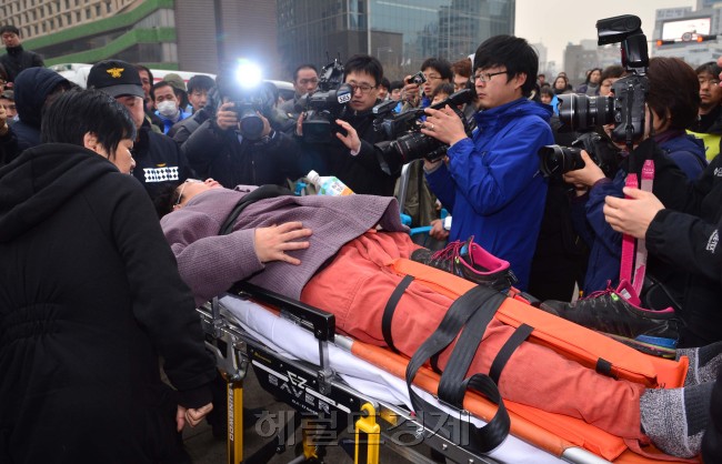 덕수궁 대한문 앞 쌍용자동차 해고노동자 농성장에서 8일 오전 강제철거를 위한 행정대집행이 실시된 가운데  농성장 앞을 막고 있던 금속노조 쌍용자동차 지부 조합원과 참가자들이 중구청 관계자들과 몸싸움을 벌이던 도중 부상자가 발생하여 응급차량으로 이동하고 있다.<br />이상섭 기자. babtong@heraldcorp.com 2013.03.08
덕수궁 대한문 앞 쌍용자동차 해고노동자 농성장에서 8일 오전 강제철거를 위한 행정대집행이 실시된 가운데  농성장 앞을 막고 있던 금속노조 쌍용자동차 지부 조합원과 참가자들이 중구청 관계자들과 몸싸움을 벌이던 도중 부상자가 발생하여 응급차량으로 이동하고 있다.
이상섭 기자. babtong@heraldcorp.com 2013.03.08