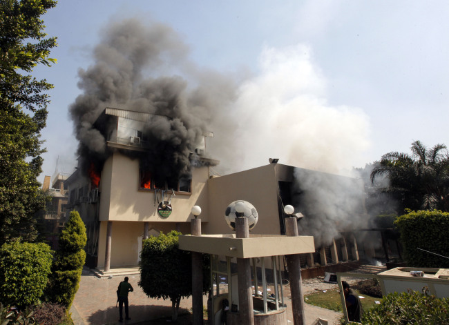 Smoke rises from the Egyptian soccer federation after protesters set it alight following a court verdict in Cairo on Saturday.   AP-Yonhap News