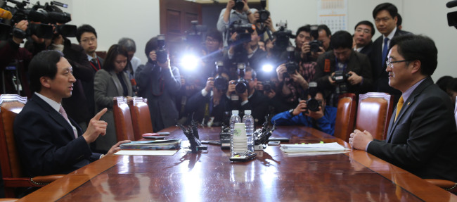 Saenuri Party senior vice floor leader Kim Gi-hyeon (left) and his Democratic United Party counterpart Woo Won-shik attend a meeting to discuss the negotiation over the government reorganization bill at the National Assembly on Friday.   Yonhap News