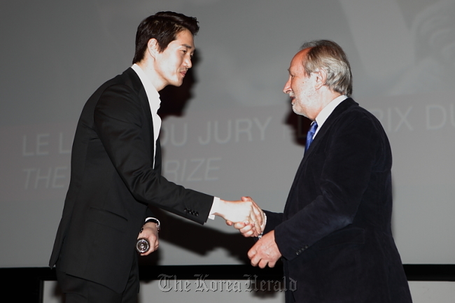 Actor-director Yoo Ji-tae (left) receives the Jury Prize from Jerome Clement (right), jury president of the Deauville Asian Film Festival, in Deauville, France, on Saturday.   Film Marketing Camp
