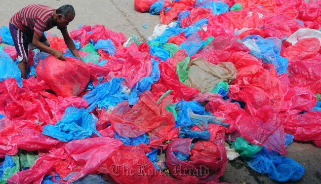 A man collects used plastic bags for recycling in Kathmandu, Nepal.   The Kathmandu Post