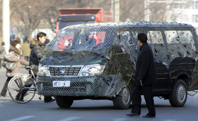 A vehicle with camouflage netting drives through a street in Pyongyang on Monday.   AP-Yonhap News