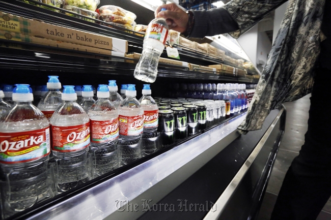 A customer takes a bottle of water off a store shelf in Jackson, Mississippi, Tuesday.   AP-Yonhap News