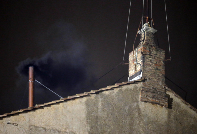 Black smoke emerges from the chimney on the roof of the Sistine Chapel in St. Peter’s Square at the Vatican on Tuesday.   AP-Yonhap News