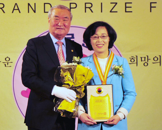 Park Chun-hee (right), mayor of Songpa district in Seoul, poses with Nam Jong-hyun, head of the Korea Association of Hanbit, after receiving the Korea Grand Prize for Sharing at 63City in Seoul on Wednesday. The association named her the prize winner.   Yonhap News