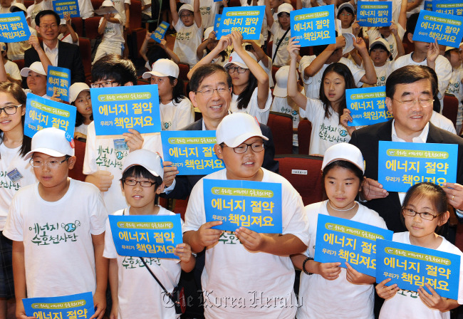 Seoul City Mayor Park Won-soon (center) poses with participants in an environmental program called “Energy Guardians” in July 2012.   Seoul Metropolitan Government