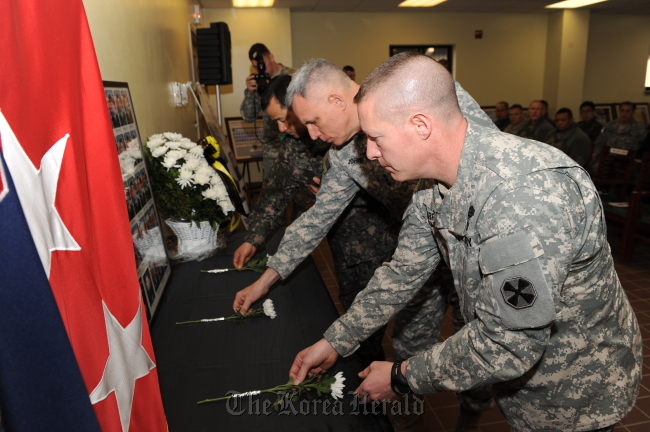 Lt. Gen. John D. Johnson (center) and his fellow troops lay chrysanthemums in front of the photos of the deceased 46 sailors of the ill-fated warship Cheonan during a memorial ceremony held at the Warrior Base on Friday.   EUSA