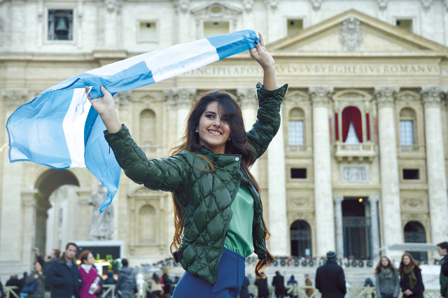 A woman poses with an Argentine flag in St. Peter’s square at the Vatican on Thursday, a day after the election of
the new pope. (AFP-Yonhap News)