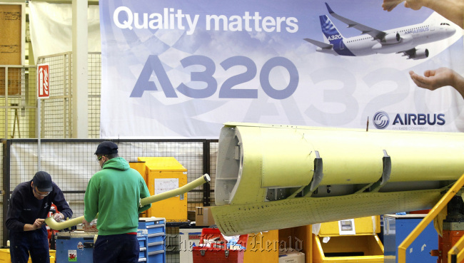Employees work on the Airbus A320 single-aisle passenger aircraft wing production line at the company’s factory in Broughton, England.  Bloomberg