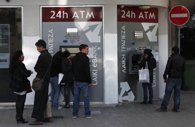 People wait and use the ATM machines outside of a Laiki Bank branch in capital Nicosia, Cyprus, Sunday.    AP-Yonhap News
