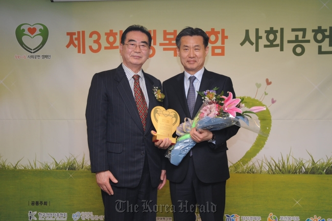BNP Paribas Cardif Life Insurance deputy chief executive Park Yong-kyun (right) and Journalists Organization of Korea chairman Sung Dae-seok pose at the 2013 Adding Happiness Social Contribution Awarding Ceremony in Seoul last week.   BNP Paribas Cardif Life